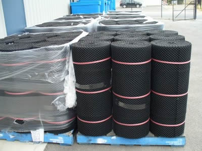 Several rolls of oyster seeding mesh tied with red rope stand on the blue pallet.